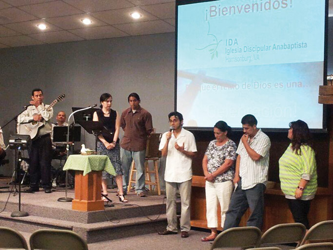 Standing with a local Latino family during a summer IDA gathering, Jossimar Diaz-Castro speaks about spiritual enrichment and immigrant rights. Courtesy of author