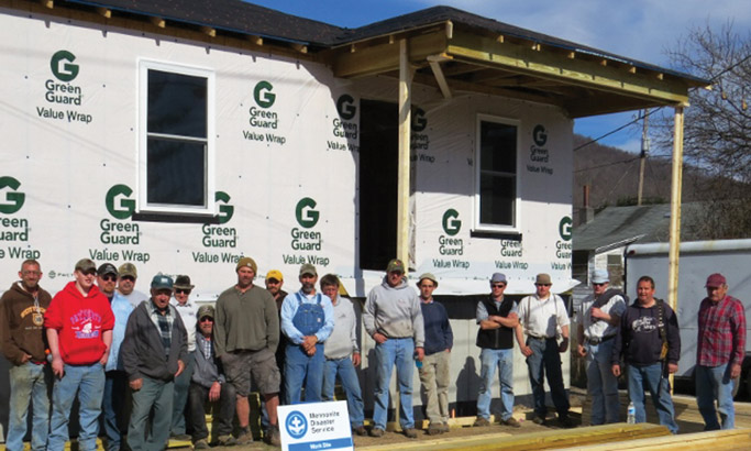 The new home build, along with a large volunteer framing group, for  the Rex family in Rainelle, West Virginia. The home owner is on the  left hand side. Photo by Rod Burkholder