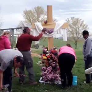 Community members in the WARM program decorate the Easter cross with flowers at Springdale Mennonite Church. Courtesy of Alan Shenk